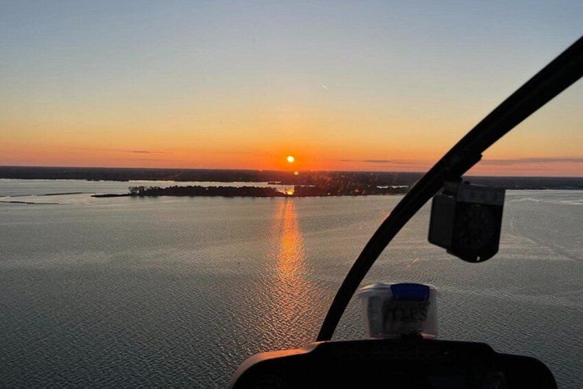A sunset over a body of water with a distant shoreline. 4