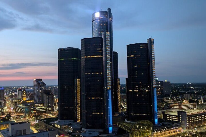 Un paisaje urbano al anochecer con rascacielos iluminados y un río al fondo. 5