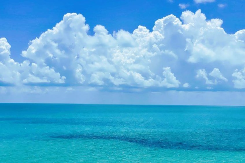 Ein türkisfarbenes Meer unter blauem Himmel mit weißen Wolken. 3