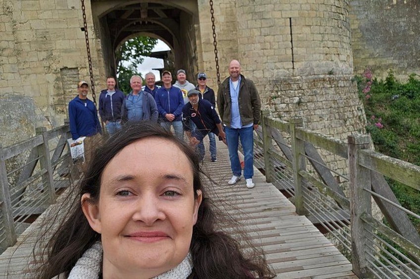 A group of people on a wooden bridge with stone walls on either side. 2
