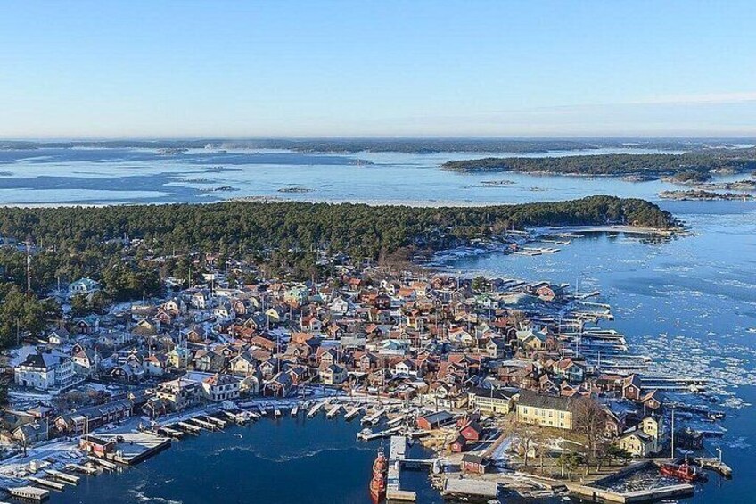 A coastal town with a marina, houses, and a forested island in the background. 5