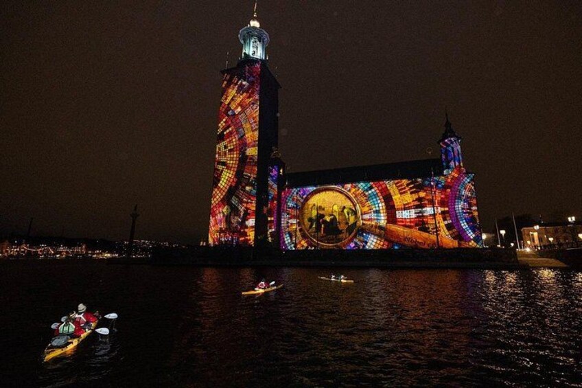 A brightly lit building with a circular window and a tower. 3