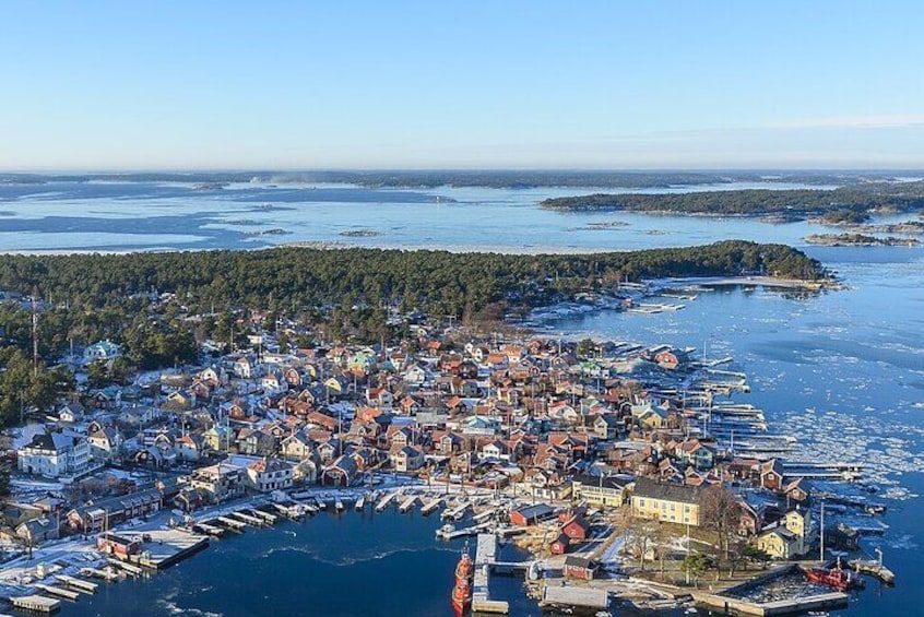 A coastal town with a marina, surrounded by forested islands. 2