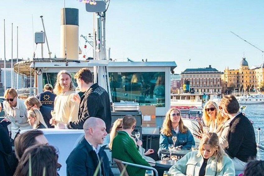 A group of people on a boat with a cityscape in the background. 1