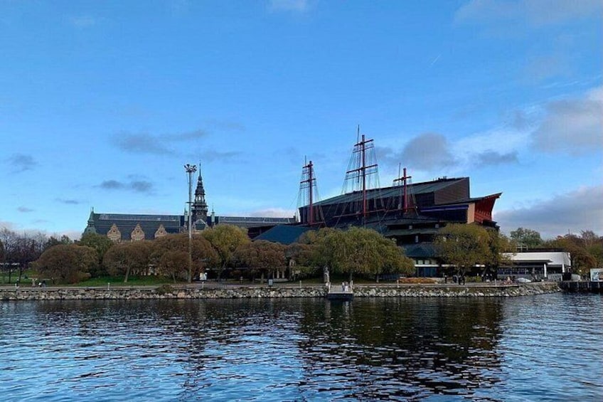 A waterfront building with a modern design, a traditional pagoda, and a large ship model. 2