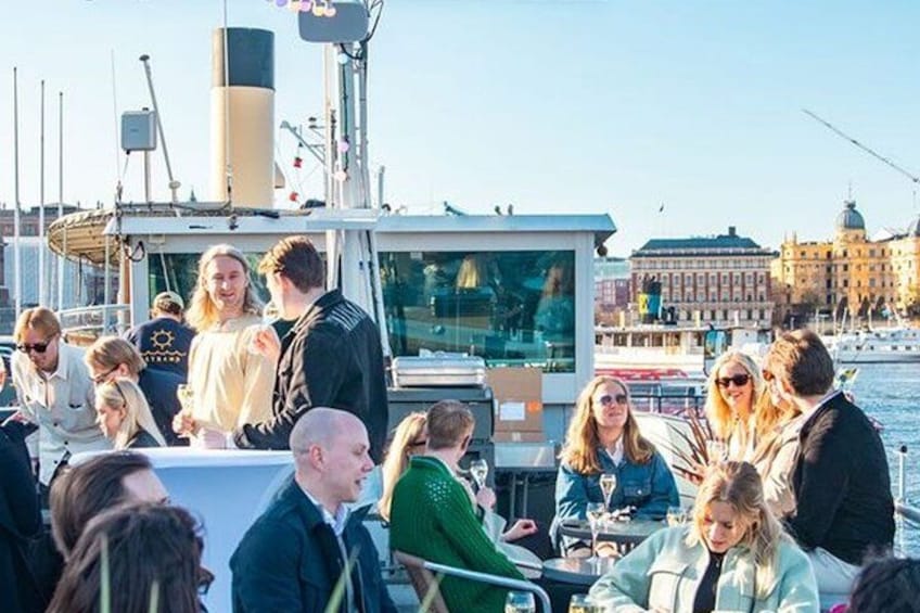 A group of people on a boat with a cityscape in the background. 1