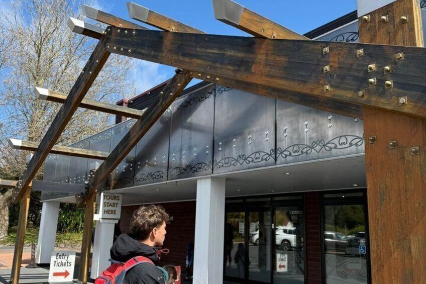A building entrance with a sign indicating 'TOURS START HERE' and a sign for 'ENTRY TICKETS.' 4