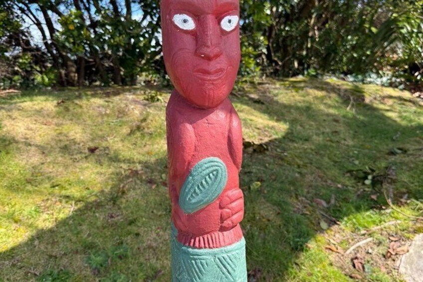 A red and green sculpture in a grassy outdoor area. 5