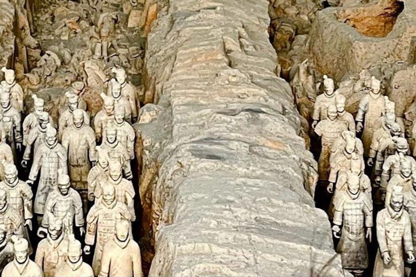 A row of ancient terracotta soldiers lined up in a formation. 4