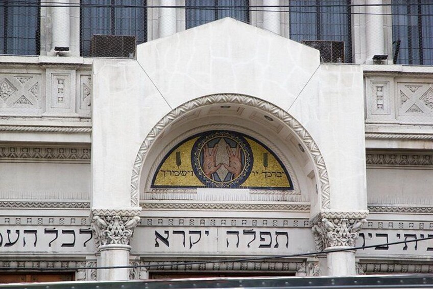 A building facade with Hebrew inscriptions and a decorative archway. 5