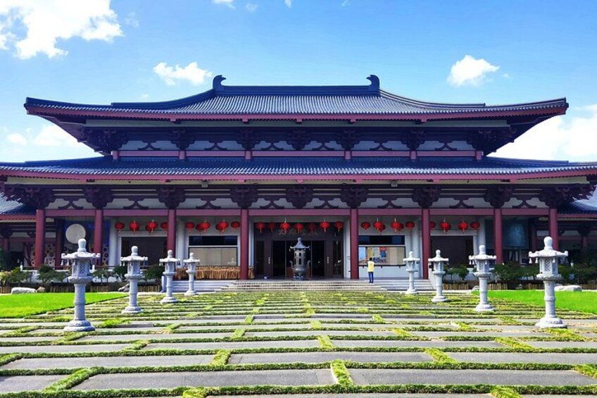 A traditional building with a multi-tiered roof and a symmetrical facade, surrounded by a well-maintained garden with stone lanterns. 4