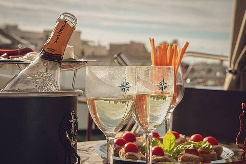 A bottle of champagne, two glasses with a star design, and a plate with food and carrot sticks. 4