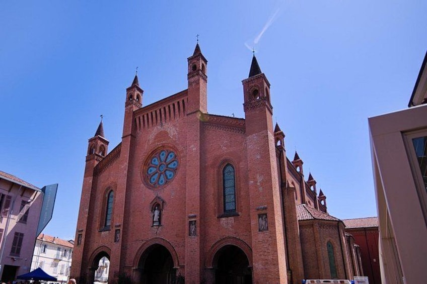 Eine rote Backsteinkirche mit einem großen Rundfenster und zwei Kirchtürmen. 1
