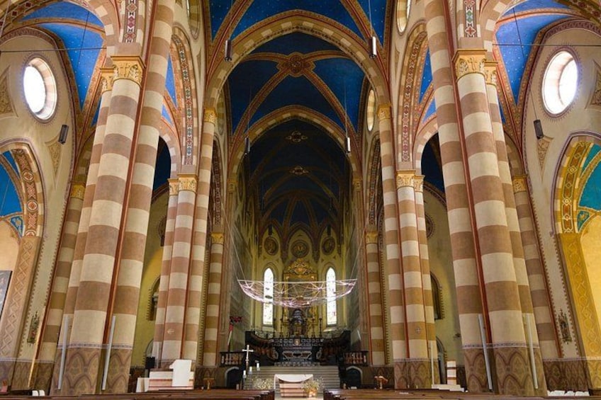 Ein Dominneres mit gestreiften Säulen, einer großen Kandelaber und einem Kruzifix am Altar. 5