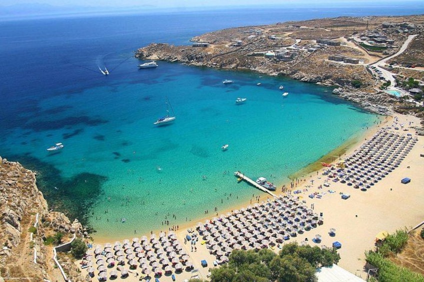 A coastal area with a beach, boats, and a clear blue sea. 1