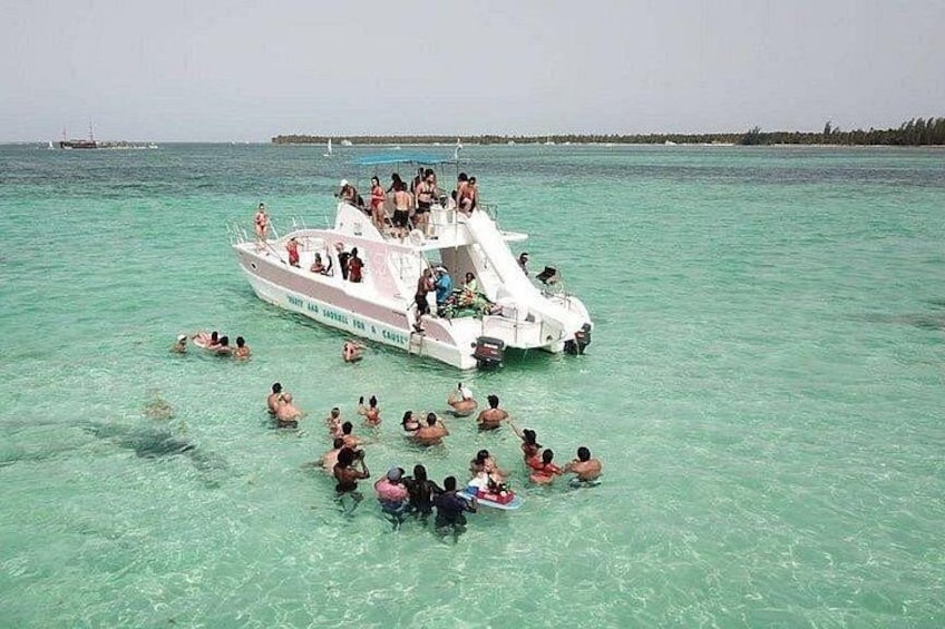 A boat with people swimming in the water. 5