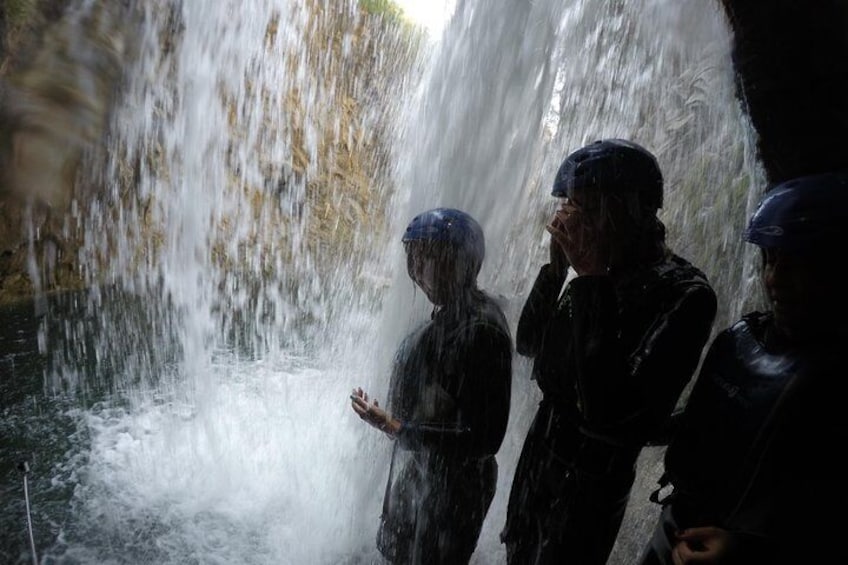 Une cascade avec des personnes debout devant. 2