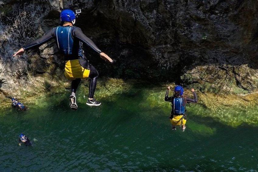 Une personne qui descend en rappel une falaise rocheuse pour atterrir dans une étendue d’eau. 4