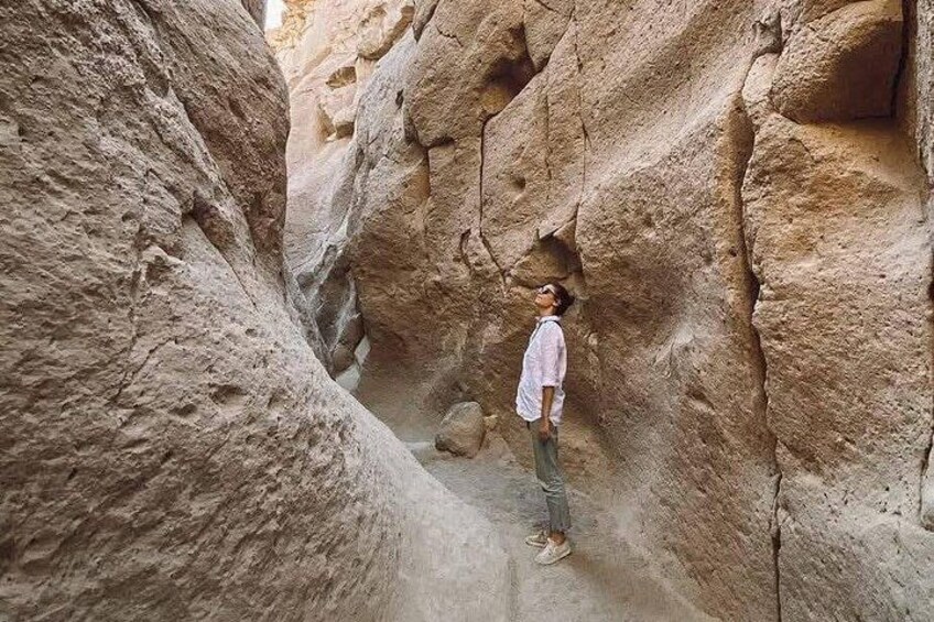 Una persona in piedi in un canyon stretto con pareti rocciose. 5