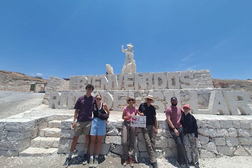 Un gruppo di persone in piedi di fronte a un monumento in pietra con l'iscrizione 'REVENUUS RIVIUS CAR'. 2