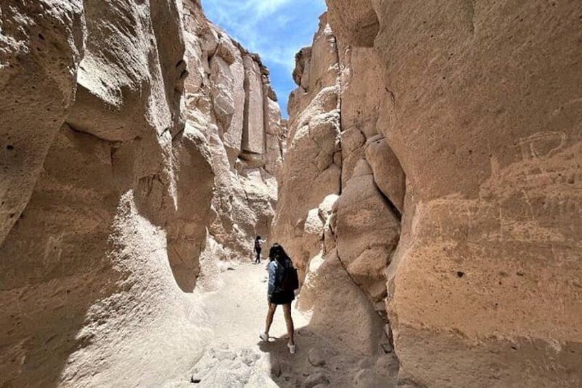 Una persona che fa trekking attraverso un canyon stretto con pareti rocciose ripide. 4