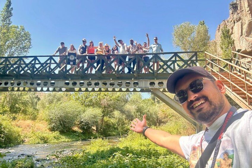 Un grupo de personas sobre un puente, con un río y vegetación abajo. 5