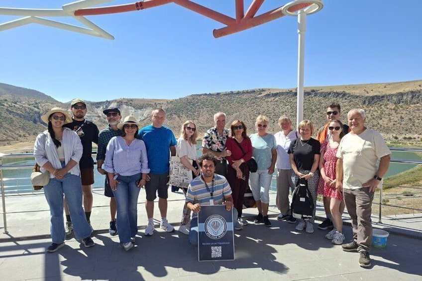 Un grupo de personas en una plataforma de concreto con un paisaje montañoso al fondo. 5