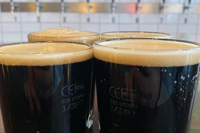 Quatre verres de bière brune surmontés d’une mousse abondante, étiquetés « Cerveza 1/3 Pint ». 2
