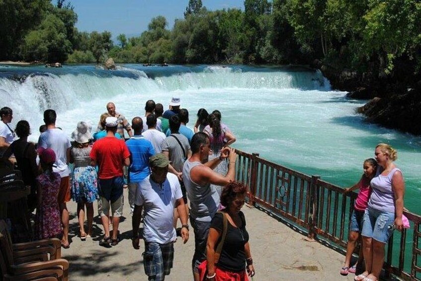 A waterfall with people observing it. 2