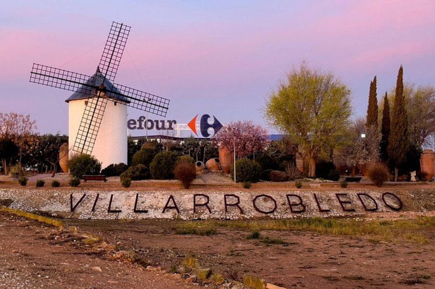 Een windmolen, een bord met 'efour' en de tekst 'VILLARROBEDO' op de grond. 3