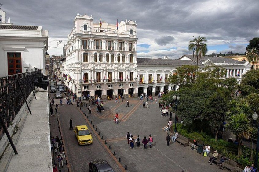 Una plaza animada con un edificio histórico, un taxi amarillo y peatones. 3