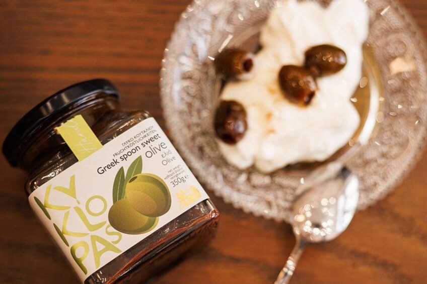 A jar of Greek spoon sweet olive and a plate with a spoonful of whipped cream and olives. 4