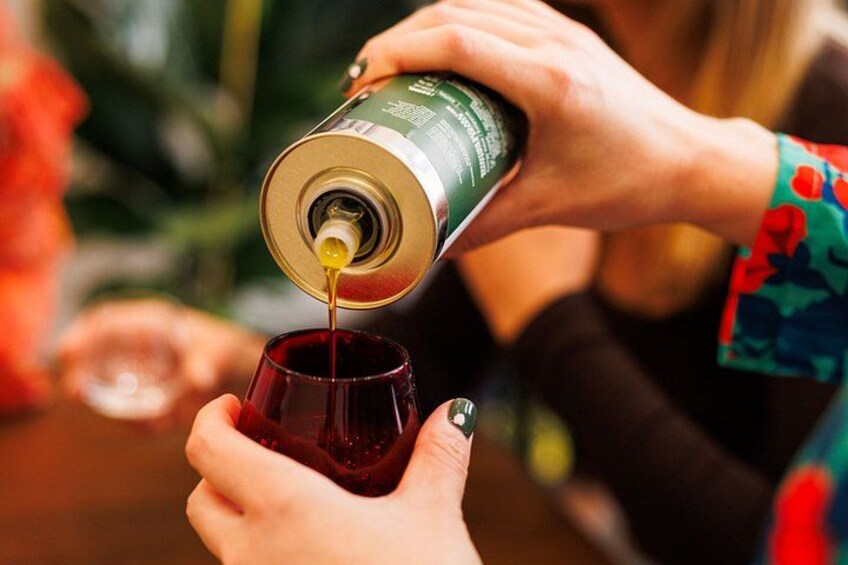 A person pouring a liquid from a can into a glass. 2