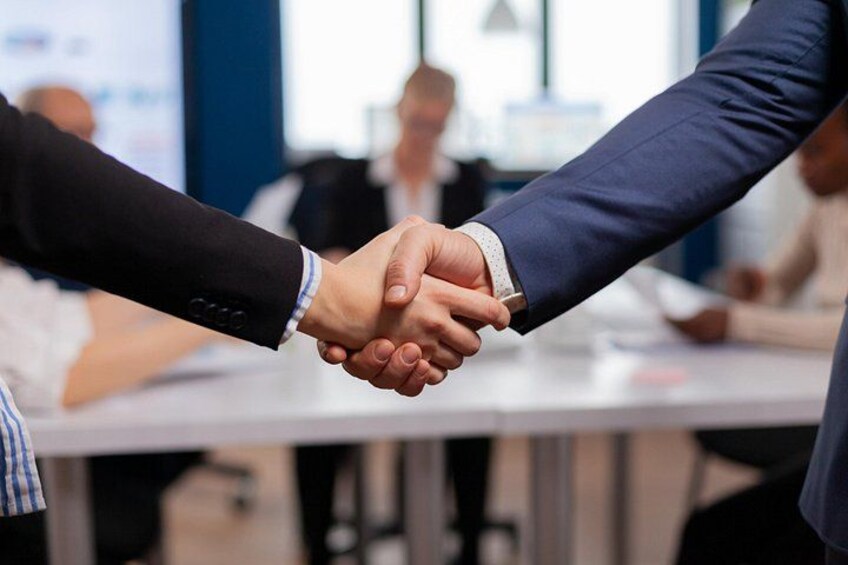 A handshake between two individuals in a business setting. 3