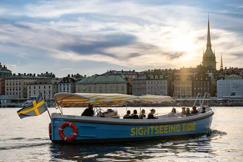 A sightseeing boat with a Swedish flag, named "SIGHTSEEING RIDE," on a body of water with a city skyline in the background. 5