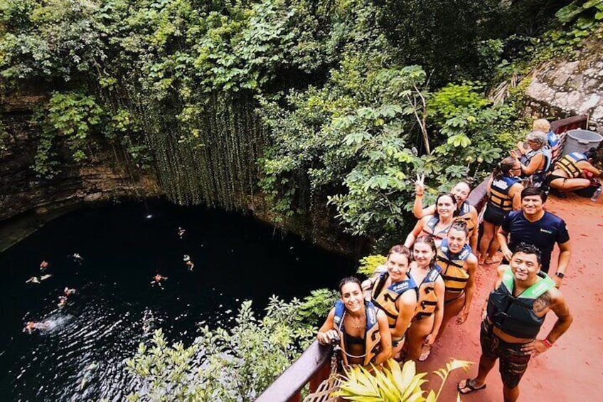A group of people on a red path near a natural pool surrounded by greenery. 5
