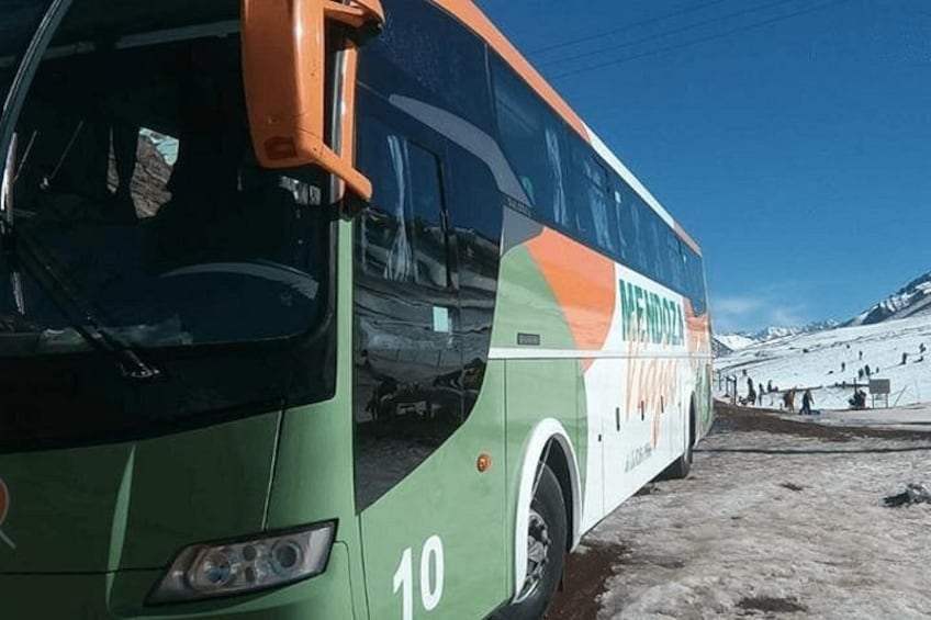 Ein grün-orangefarbener Bus mit der Nummer 10 steht auf verschneiter Fahrbahn. 5