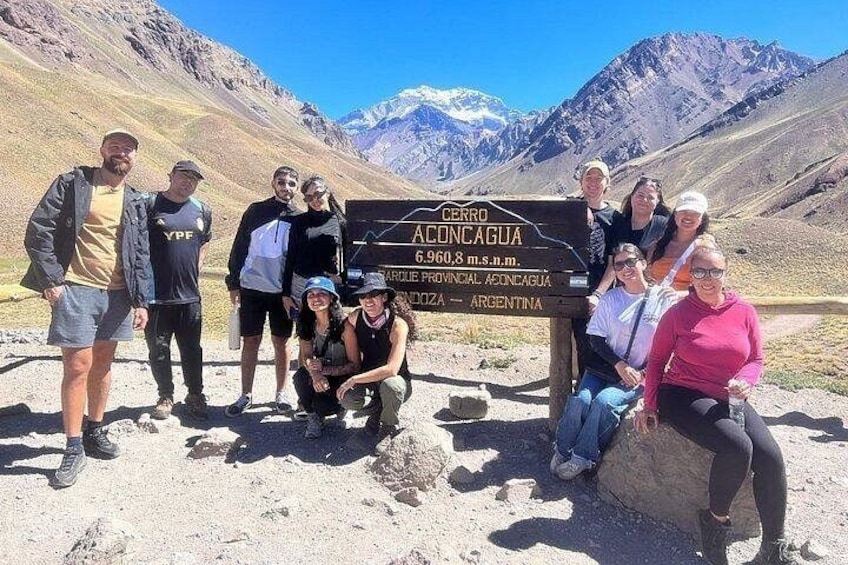 Eine Gruppe von Personen steht vor einem Schild mit dem Text 'CERRO CONCAGUA 6.960 m.s.n.m.'. 1