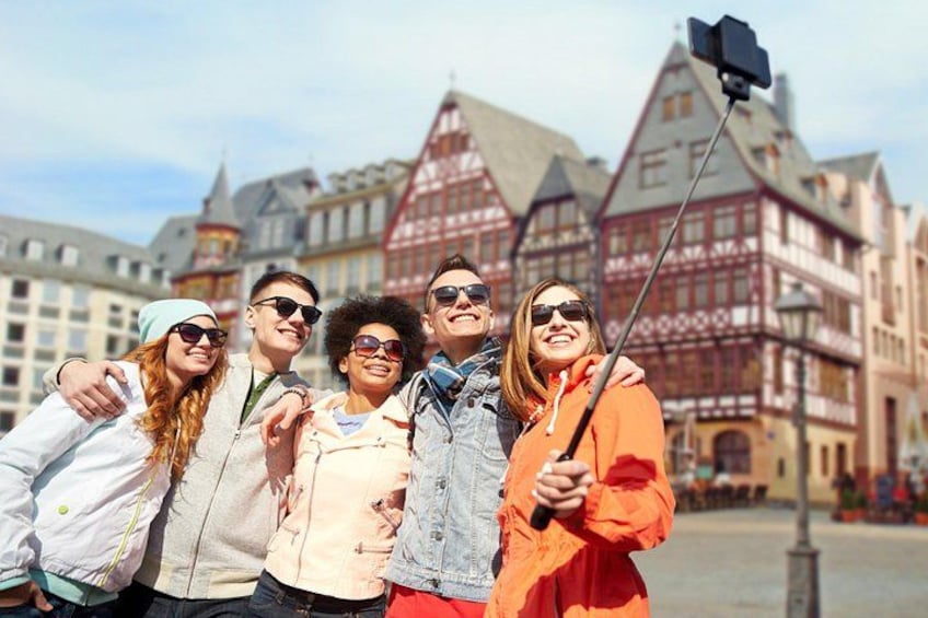 A group of people taking a selfie with a historic building in the background. 4