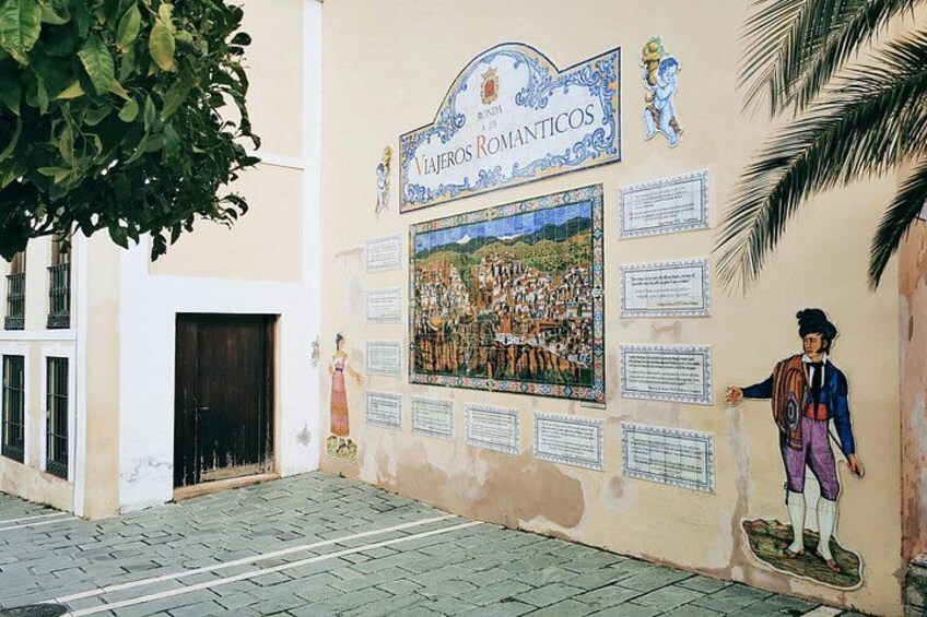 A mural with a historical scene, a door, and a statue. 5