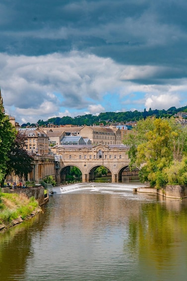 A stone bridge over a river with buildings in the background. 4