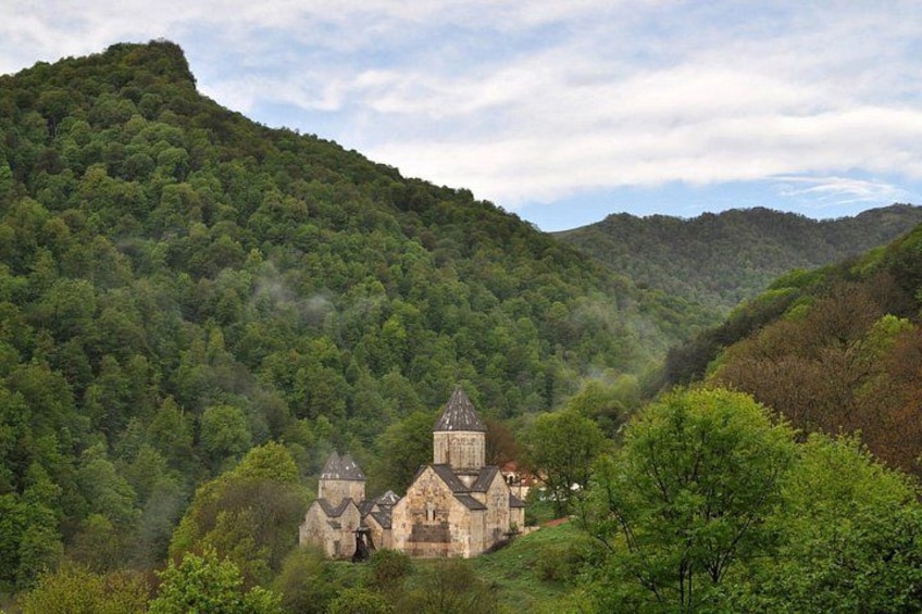 Una iglesia de piedra histórica rodeada de colinas verdes exuberantes. 5