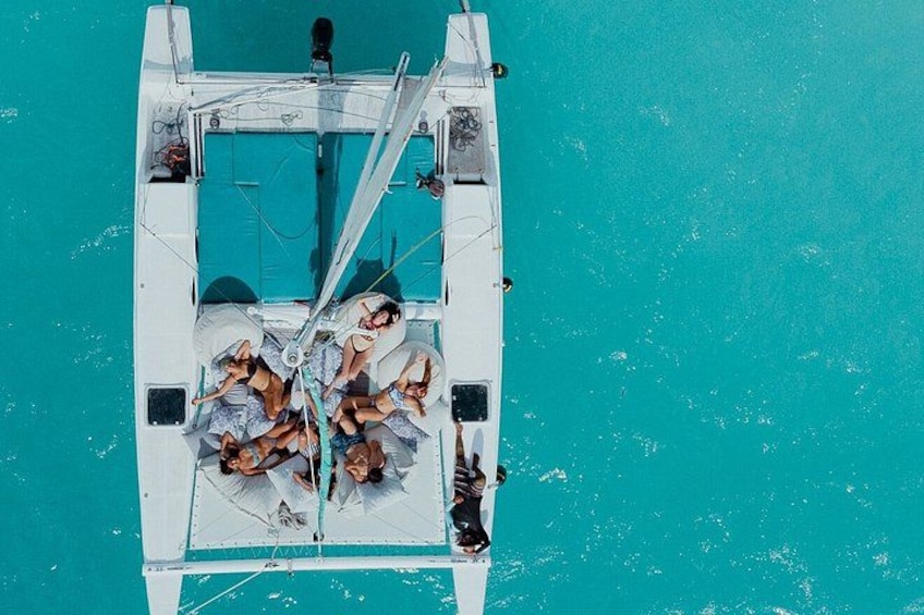 A boat with people on deck, surrounded by turquoise water. 2