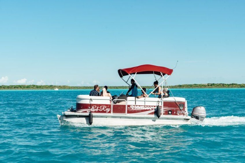 A boat with 'El Rey' written on the side, moving through clear blue water. 2