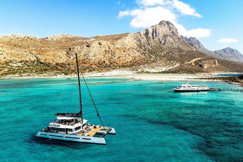 Un voilier sur une eau turquoise, avec un paysage montagneux en arrière-plan. 5