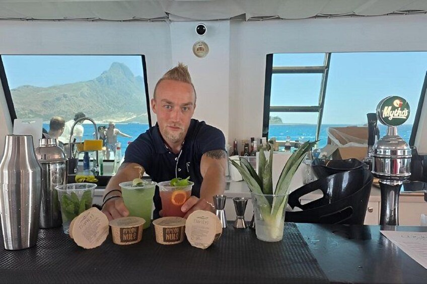 Un barman travaille dans un bar où l’on sert des boissons et d’où l’on a une vue sur l’océan. 2