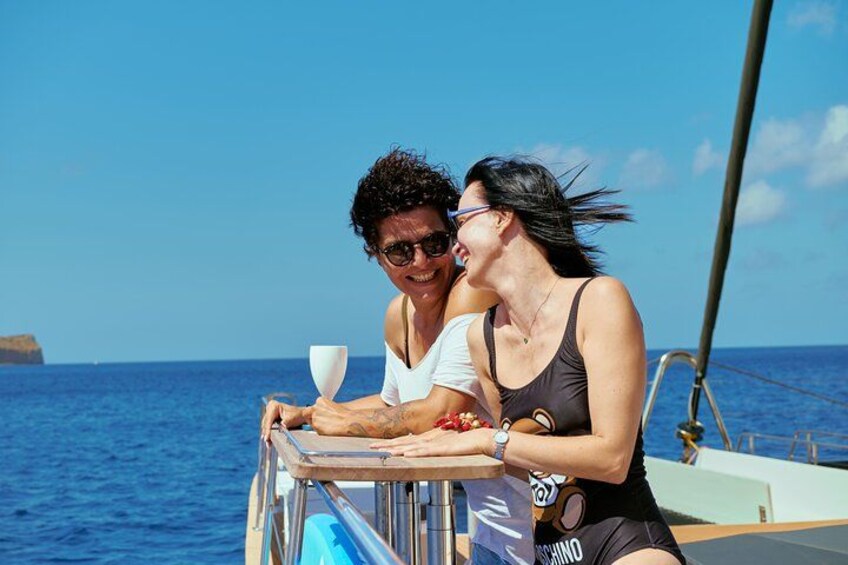 Two people on a boat with a clear blue sky and ocean in the background. 3