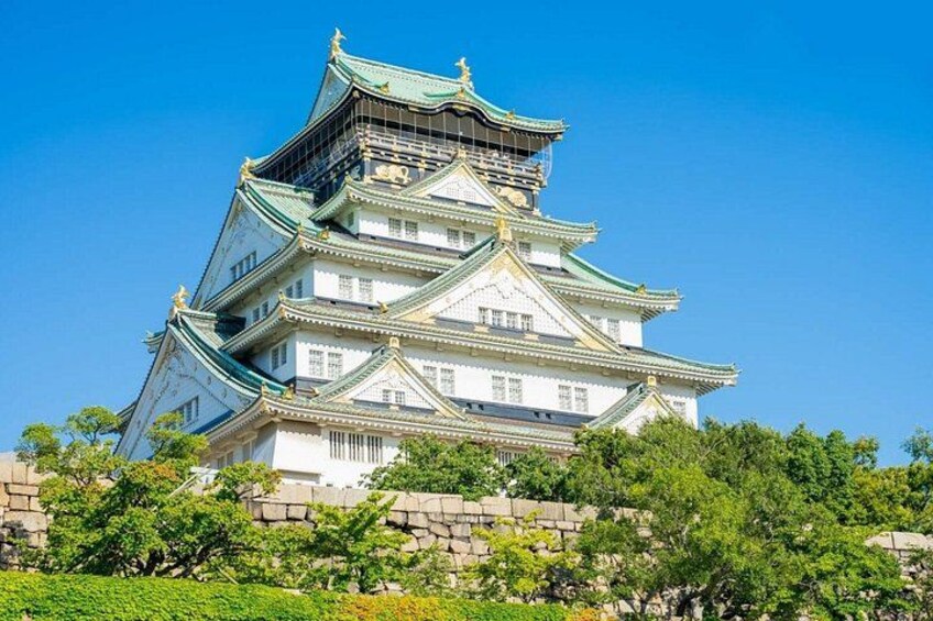 Eine traditionelle japanische Burg mit mehreren Geschossen und grünen Dächern. 5