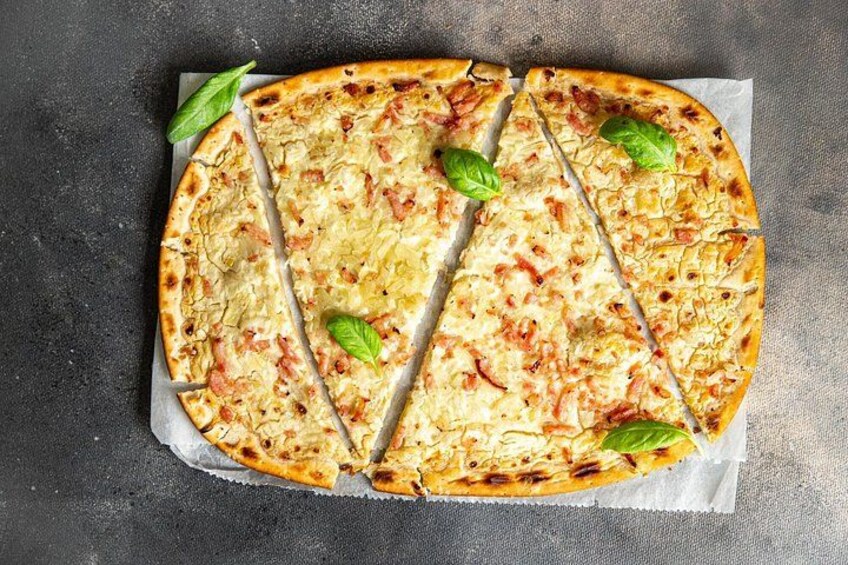 A pizza with slices cut out, placed on a dark surface. 3