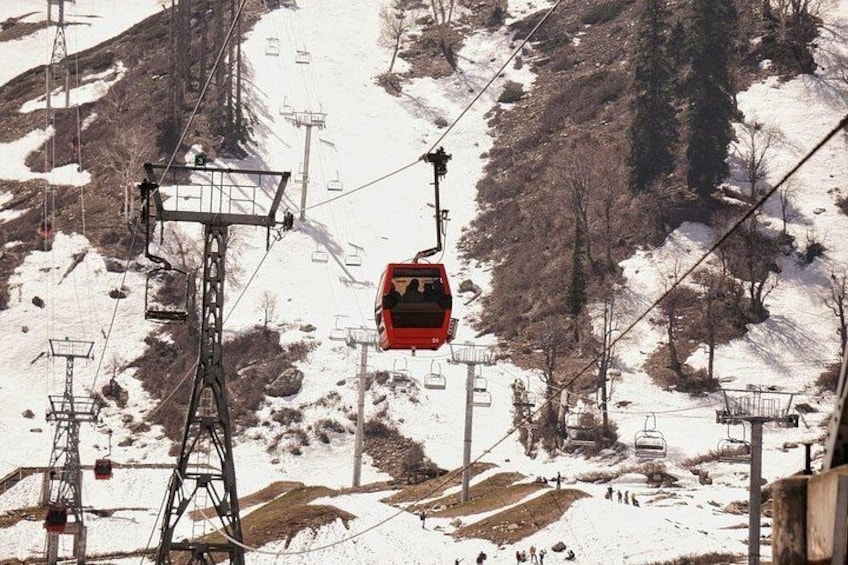 Un telesilla rojo transporta pasajeros por una montaña nevada. 1